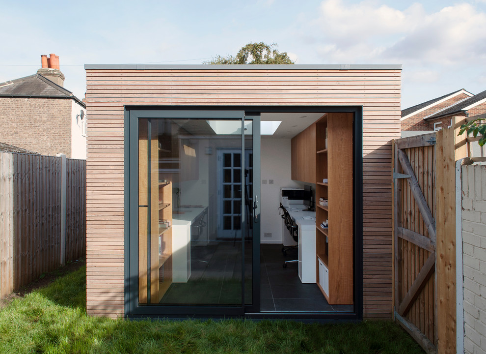 Photo of a small scandi bungalow house exterior in London with wood cladding and a flat roof.