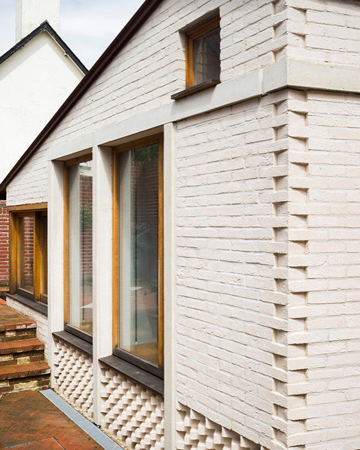 Modelo de fachada de casa pareada blanca campestre pequeña de una planta con revestimiento de ladrillo, tejado a dos aguas y tejado de metal