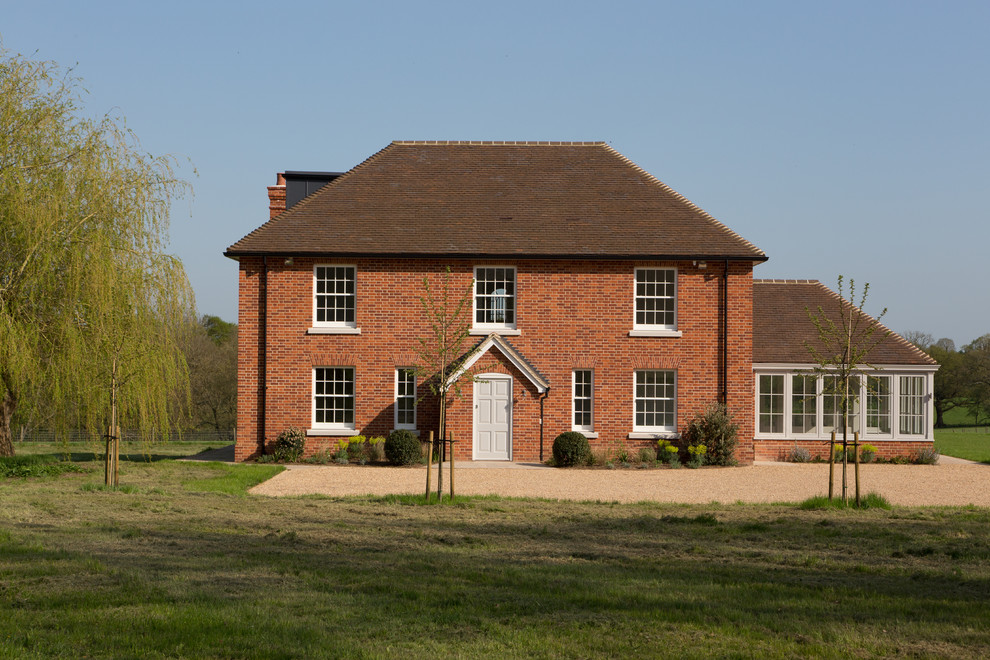 Modelo de fachada de casa roja tradicional grande de tres plantas con revestimiento de ladrillo, tejado a dos aguas y tejado de teja de barro
