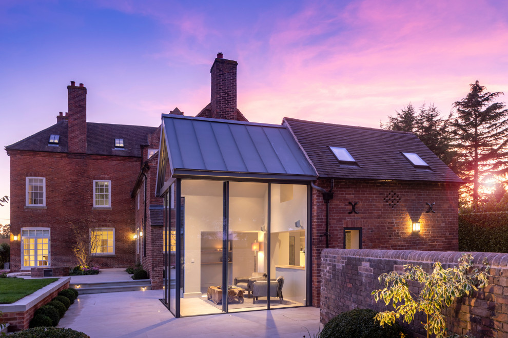 Large trendy three-story metal exterior home photo in West Midlands with a metal roof