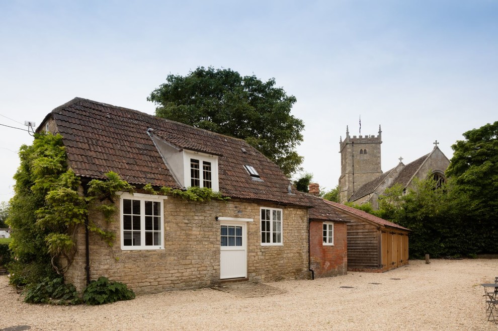 Inspiration for a small and beige country two floor detached house in Wiltshire with stone cladding, a half-hip roof and a tiled roof.
