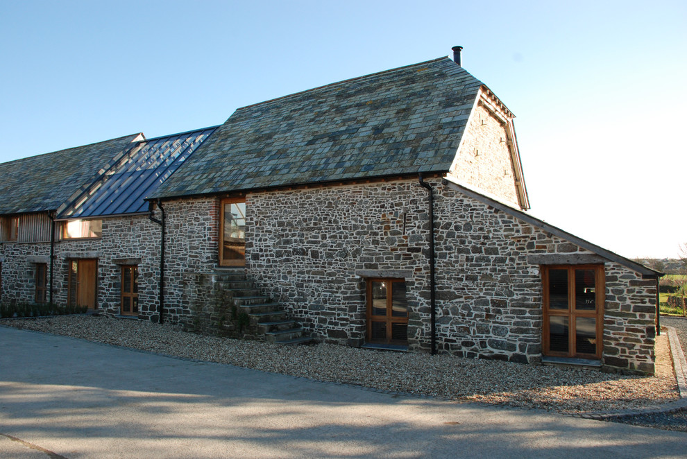 Diseño de fachada de casa gris y gris rural extra grande de dos plantas con revestimiento de piedra y tejado a la holandesa