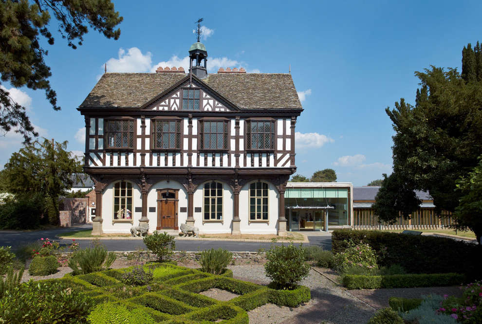 Inspiration for a large timeless white three-story wood house exterior remodel in West Midlands