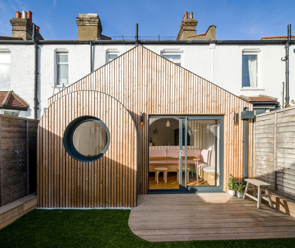 Inspiration pour une petite façade de maison de ville traditionnelle en bois de plain-pied avec un toit à deux pans et un toit végétal.