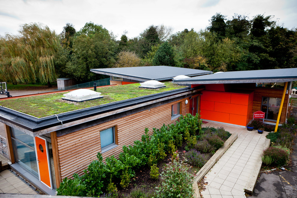 Idee per la facciata di una casa grande moderna con tetto piano e copertura verde