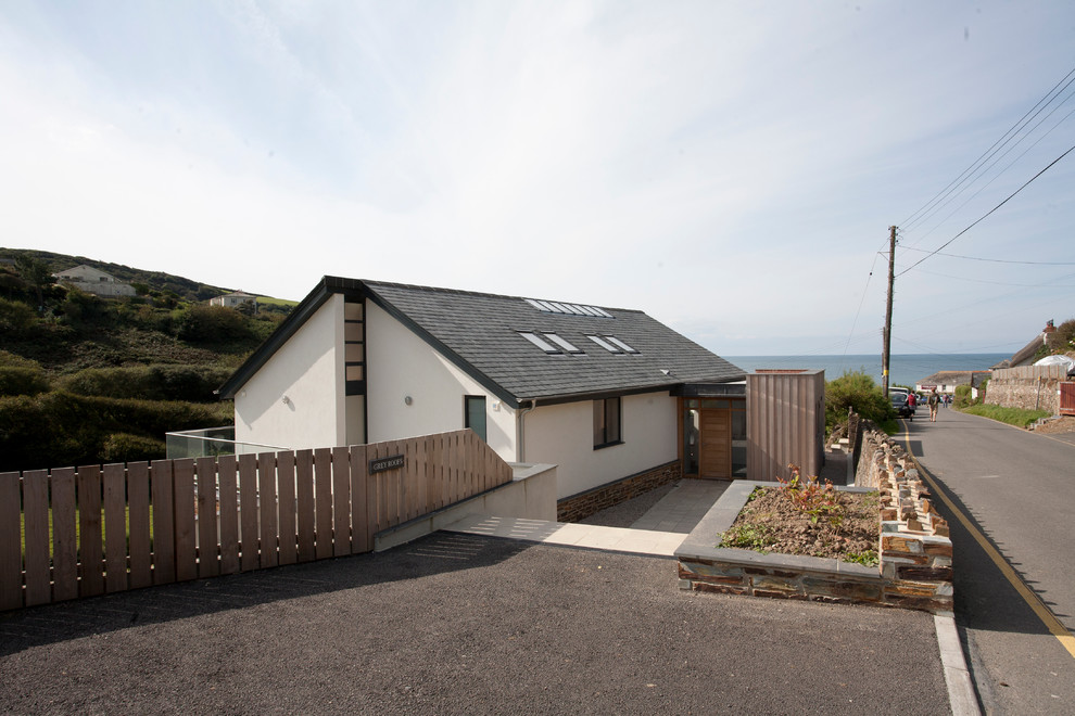 This is an example of a medium sized and white nautical two floor render and front detached house in Cornwall with a pitched roof, a tiled roof and a grey roof.