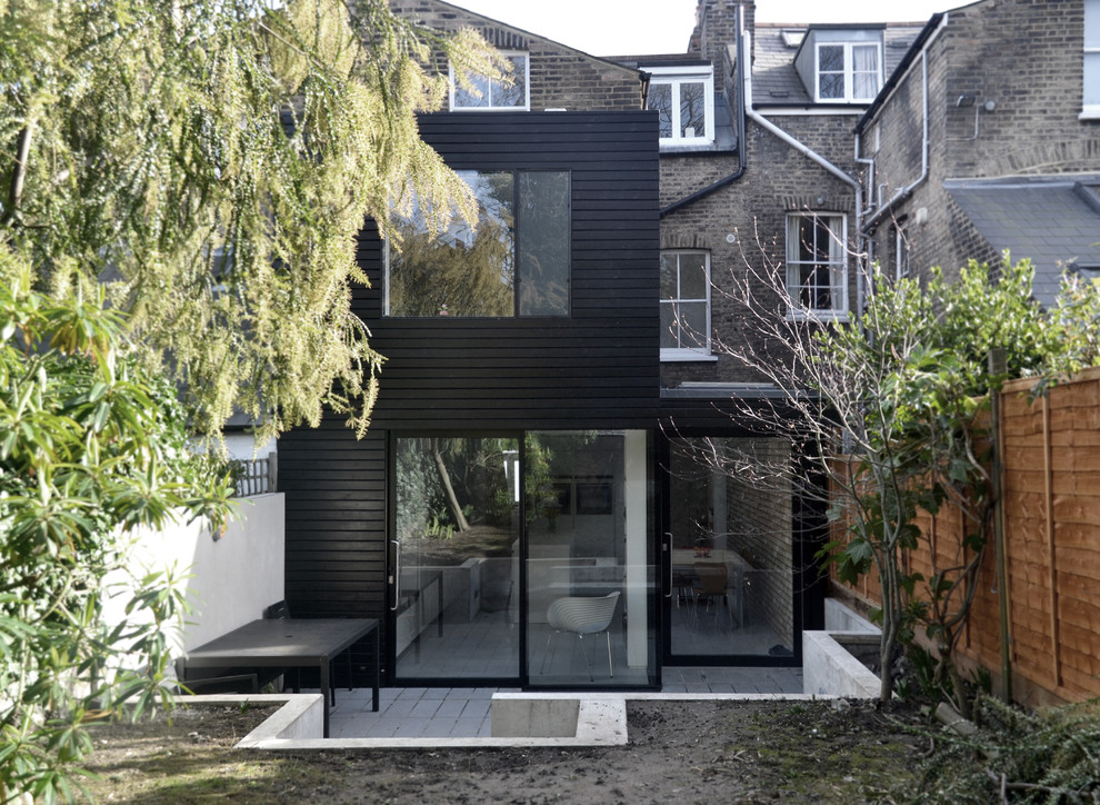Inspiration för små moderna svarta trähus, med platt tak