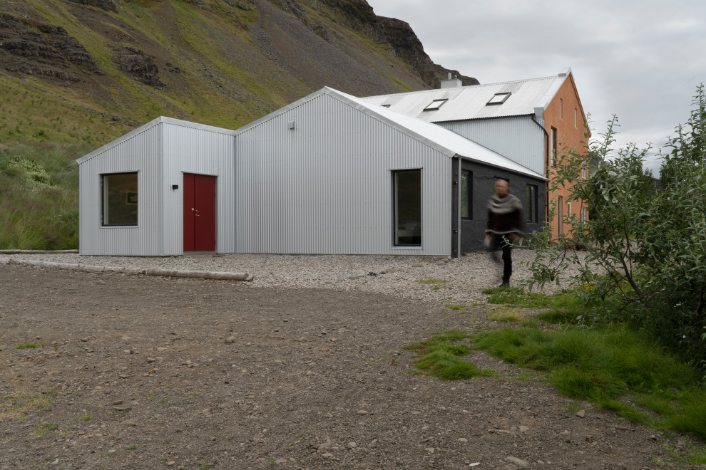Ejemplo de fachada de casa multicolor escandinava grande de tres plantas con revestimiento de metal, tejado a dos aguas y tejado de metal