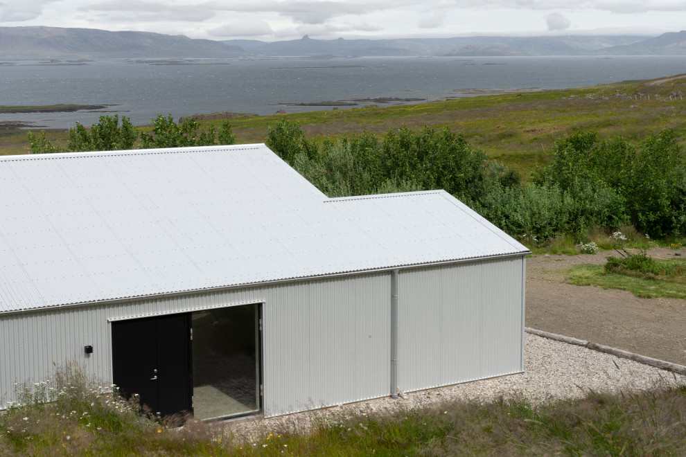 Foto della villa grande multicolore scandinava a tre piani con rivestimento in metallo, tetto a capanna e copertura in metallo o lamiera