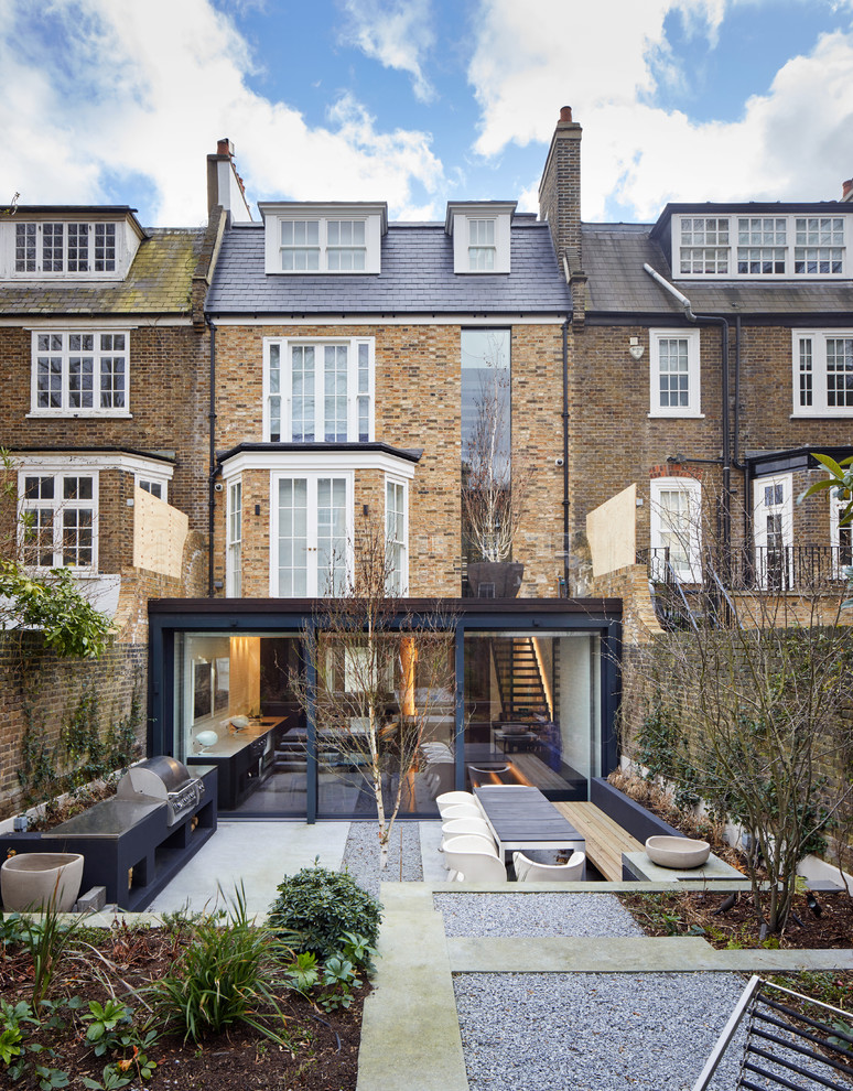 Example of a mid-sized trendy three-story brick townhouse exterior design in London