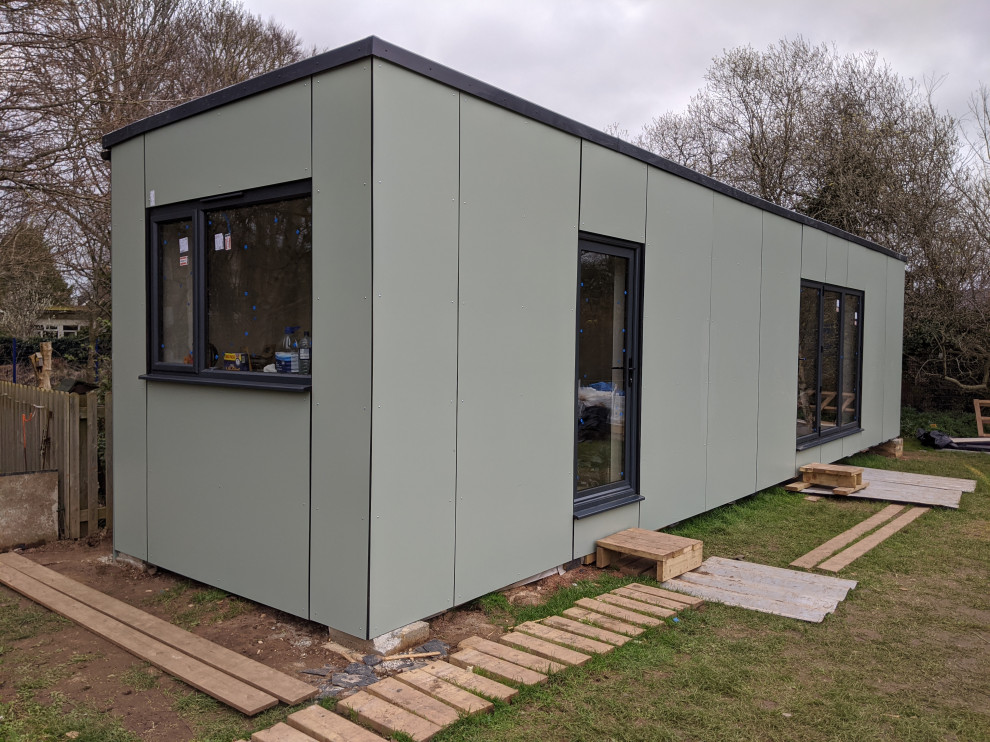 Idée de décoration pour une petite façade de maison container verte design de plain-pied avec un revêtement mixte, un toit plat et un toit mixte.