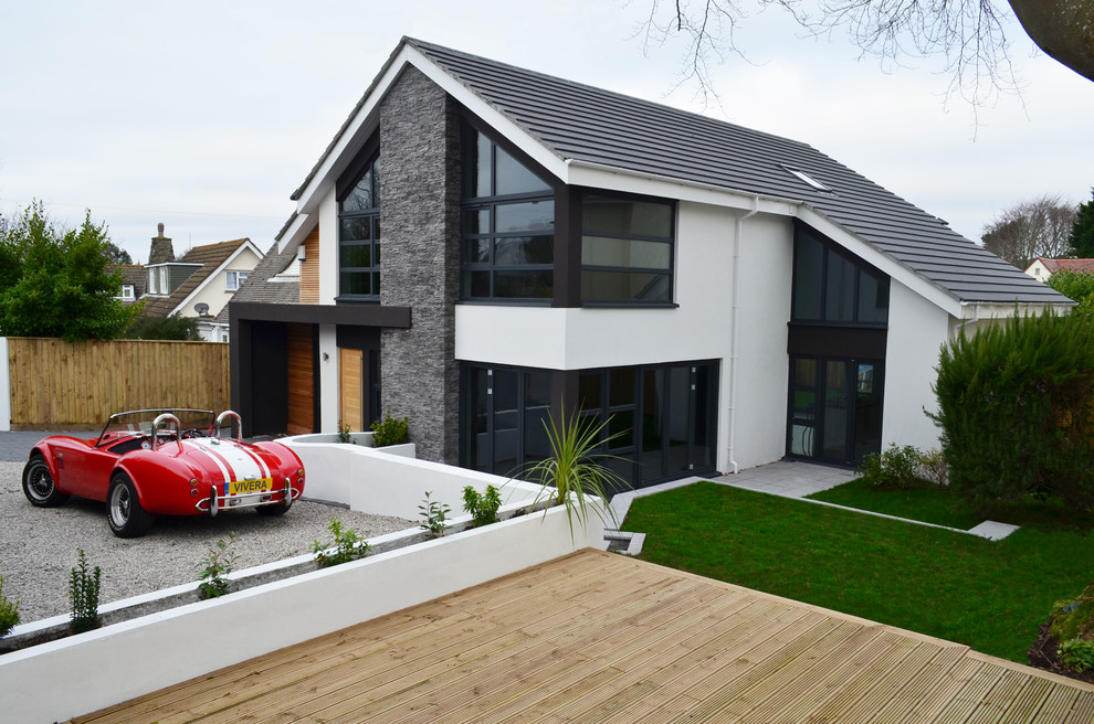 Foto de fachada blanca moderna de tamaño medio de dos plantas con revestimiento de piedra y tejado a dos aguas