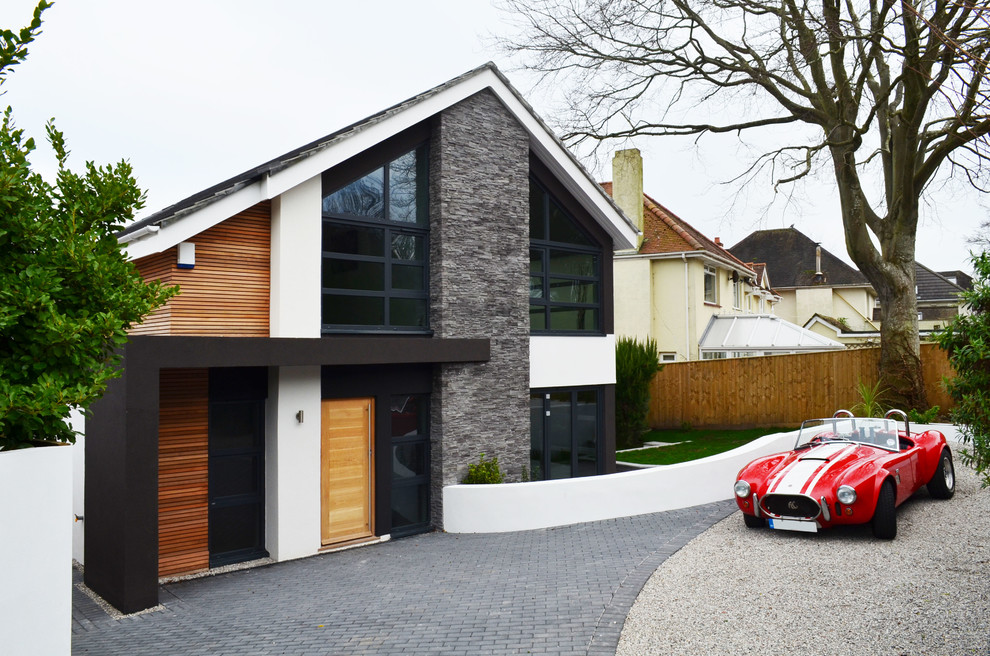 Идея дизайна: двухэтажный, белый дом среднего размера в стиле модернизм с облицовкой из камня и двускатной крышей