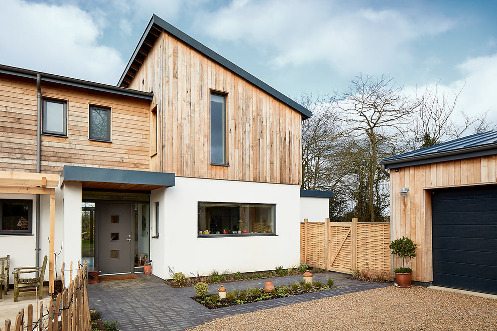 Cette image montre une façade de maison blanche minimaliste en bois de taille moyenne et à un étage avec un toit mixte.