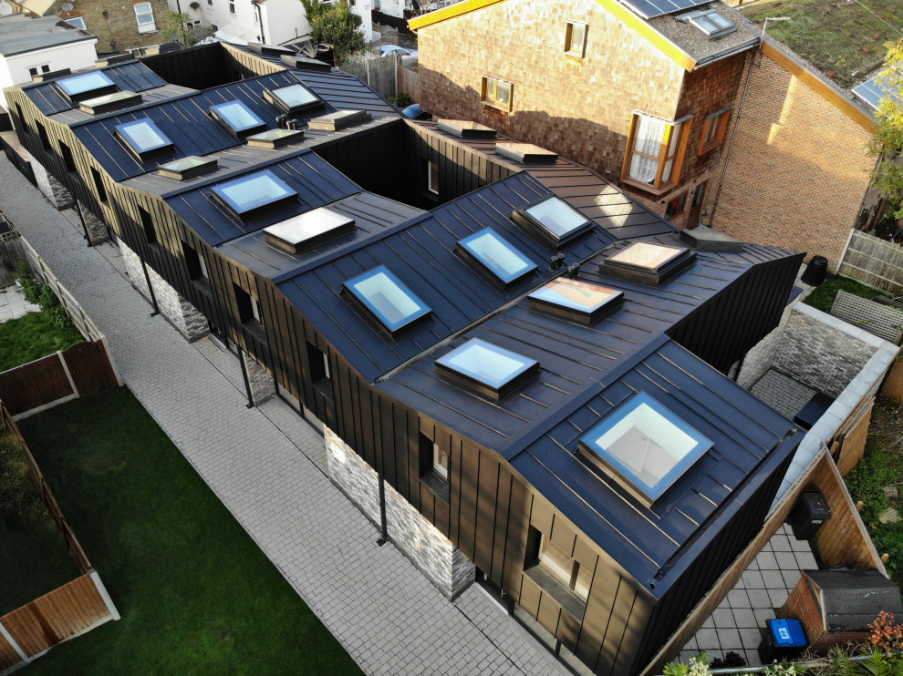 Inspiration for a large and black contemporary two floor terraced house in London with metal cladding, a pitched roof and a metal roof.