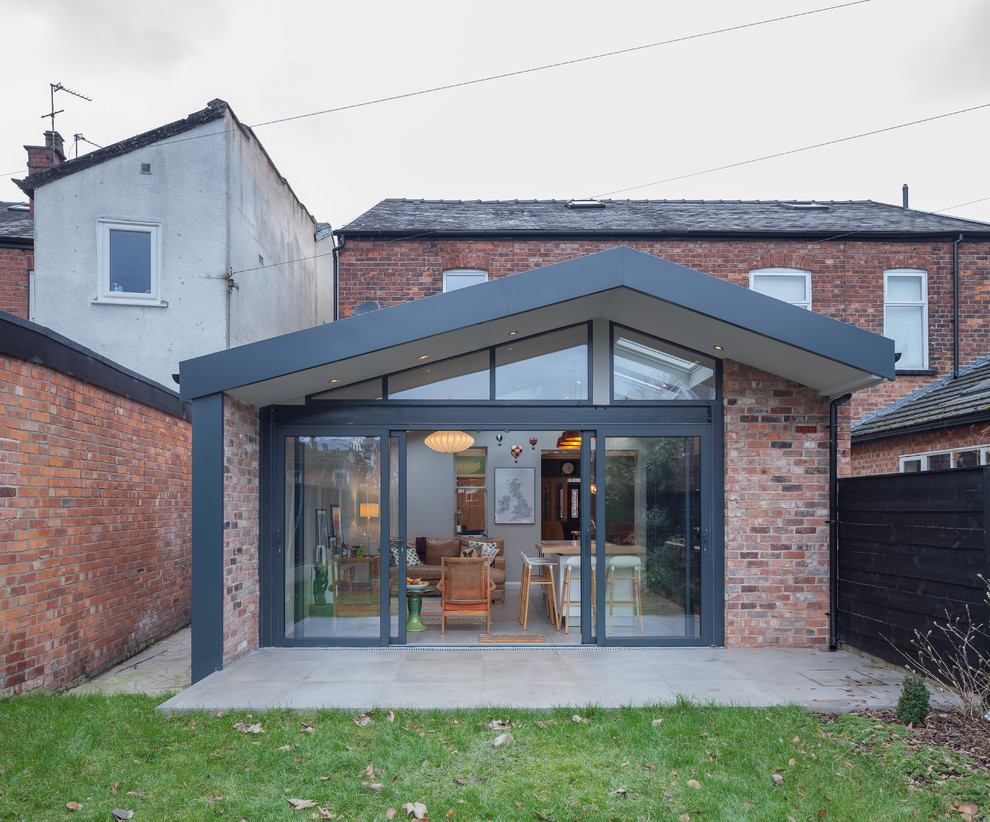 Inspiration for a medium sized and red contemporary two floor brick semi-detached house in Manchester with a pitched roof and a tiled roof.