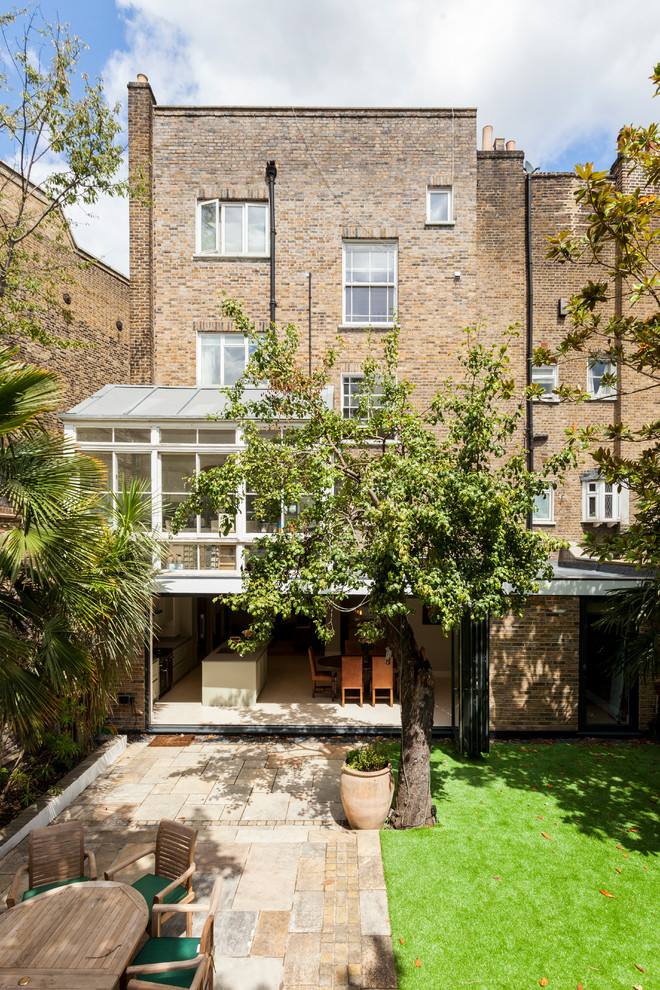 Inspiration for a classic brick house exterior in London with three floors and a flat roof.