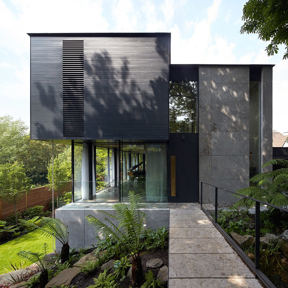 Foto på ett funkis grått hus, med allt i ett plan, blandad fasad och platt tak