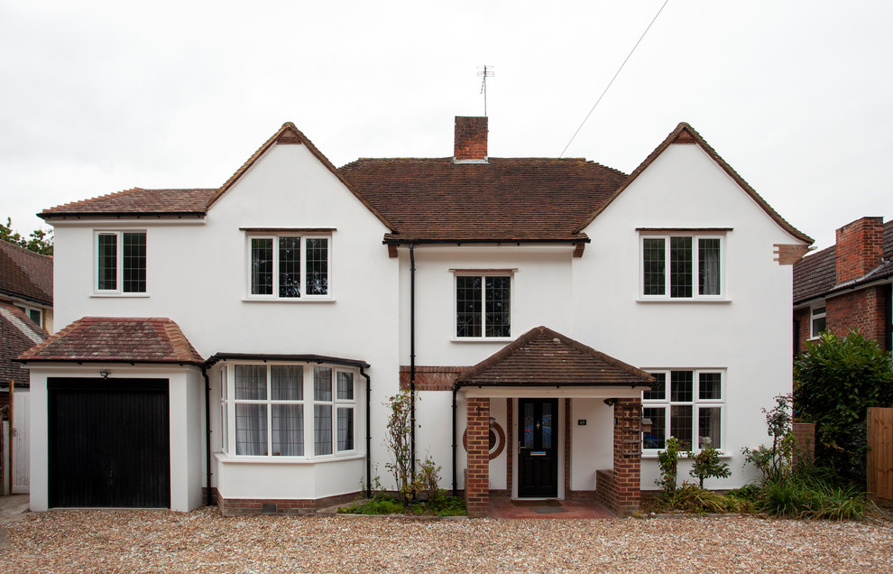 This is an example of a large and white traditional two floor render detached house in Surrey with a hip roof and a tiled roof.
