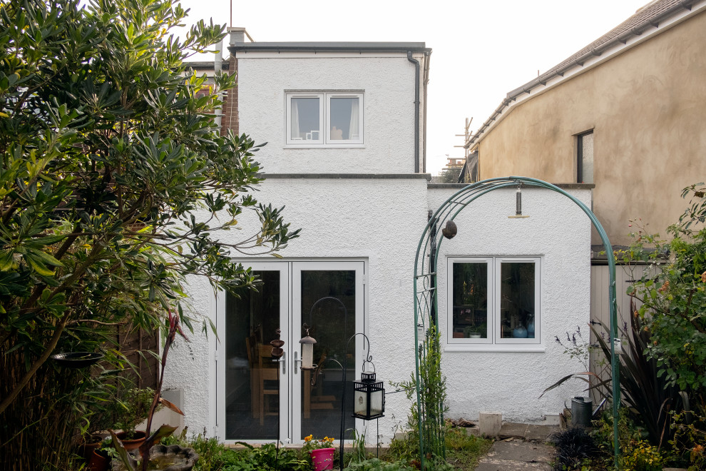 Kleines, Zweistöckiges Modernes Haus mit Putzfassade, weißer Fassadenfarbe und Flachdach in London