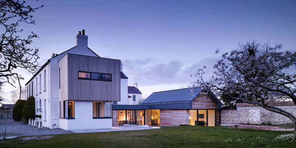 Huge contemporary white two-story wood gable roof idea in Dublin