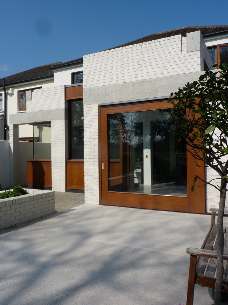 Idee per la facciata di una casa bianca moderna di medie dimensioni con rivestimento in mattoni