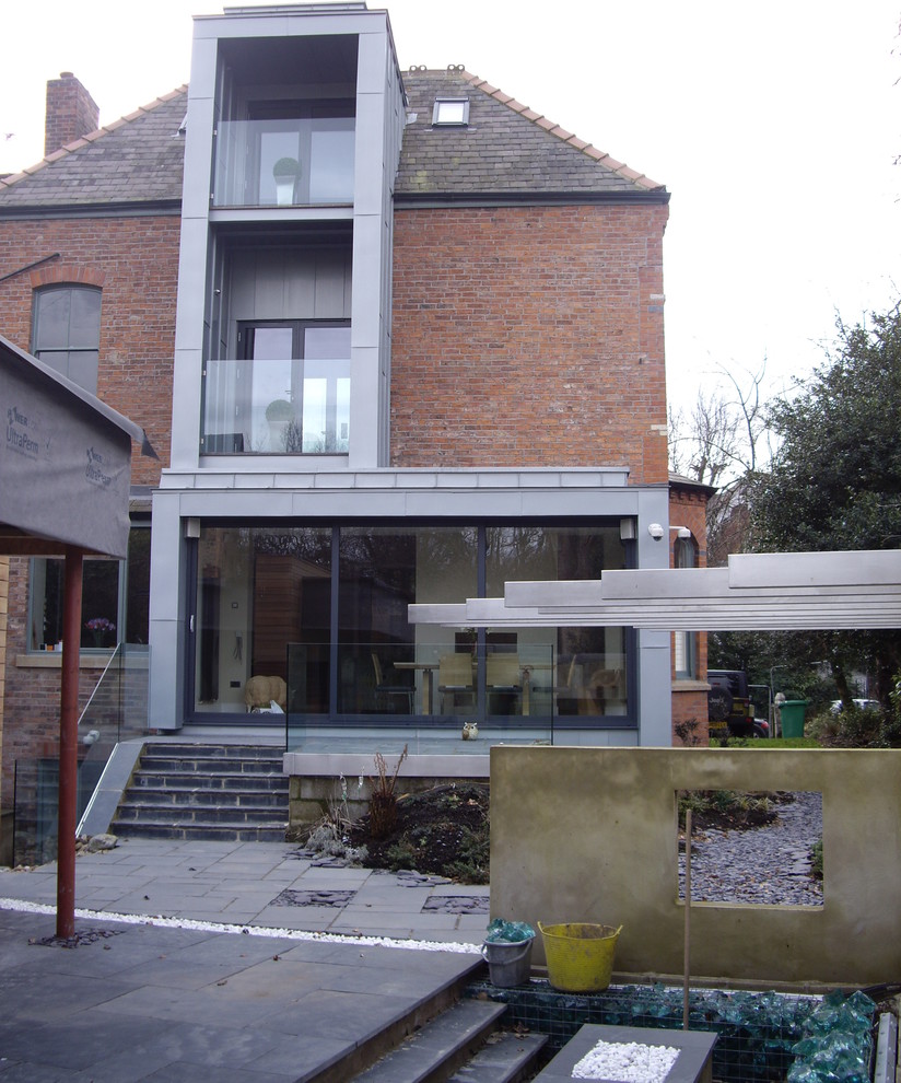 Diseño de fachada gris industrial de tres plantas con revestimientos combinados y tejado plano