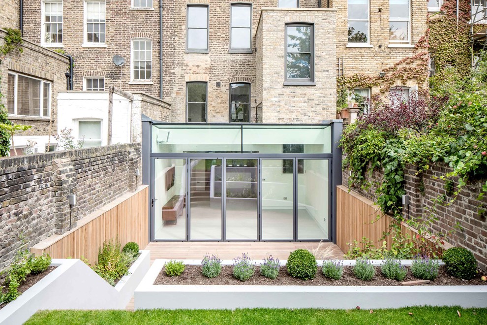 Mittelgroßes, Dreistöckiges Modernes Haus mit Glasfassade, grauer Fassadenfarbe und Flachdach in London