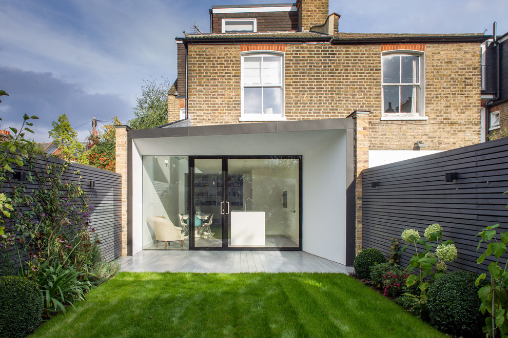 Photo of a beige contemporary two floor brick and rear extension in London.