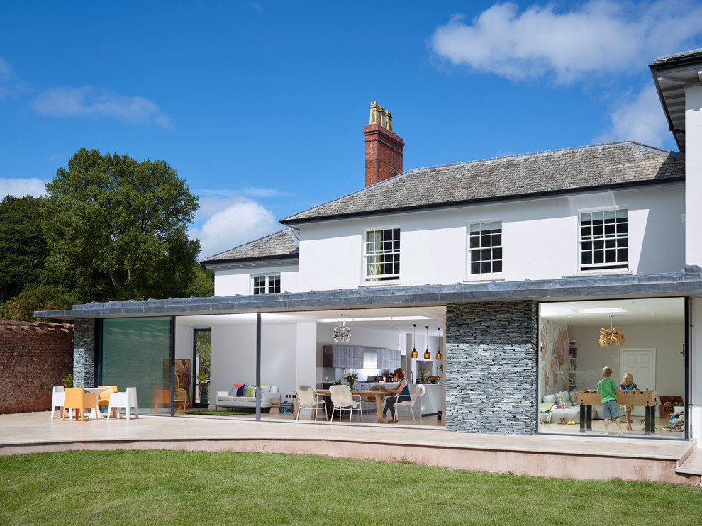 Design ideas for a white contemporary two floor house exterior in Devon with stone cladding.