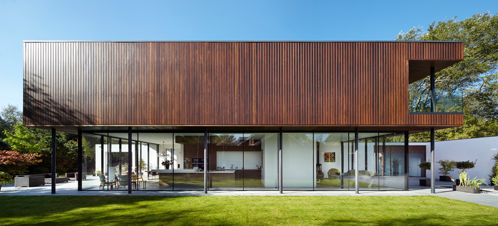 Imagen de fachada marrón actual de dos plantas con revestimiento de madera y tejado plano