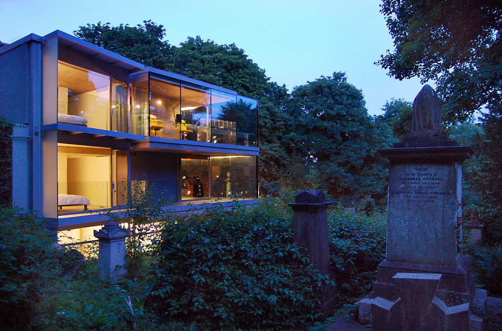Large and gey contemporary glass house exterior in London with three floors.