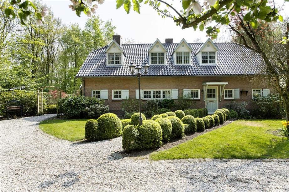 Design ideas for a large and beige farmhouse two floor brick house exterior in Amsterdam with a pitched roof.