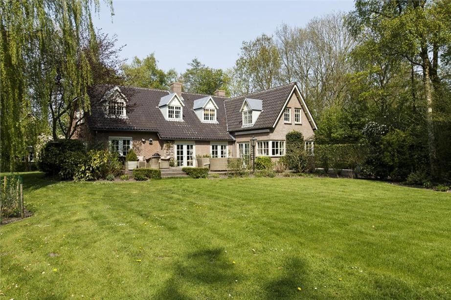 Design ideas for a beige farmhouse two floor brick house exterior in Amsterdam with a pitched roof.