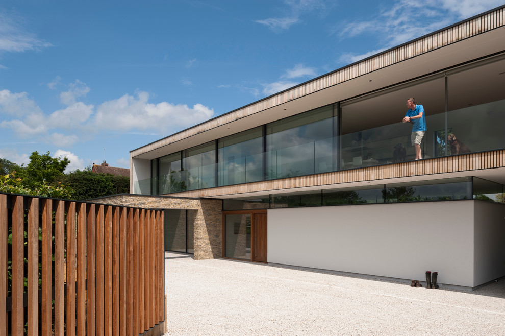 Design ideas for a contemporary two floor house exterior in Hampshire with wood cladding.