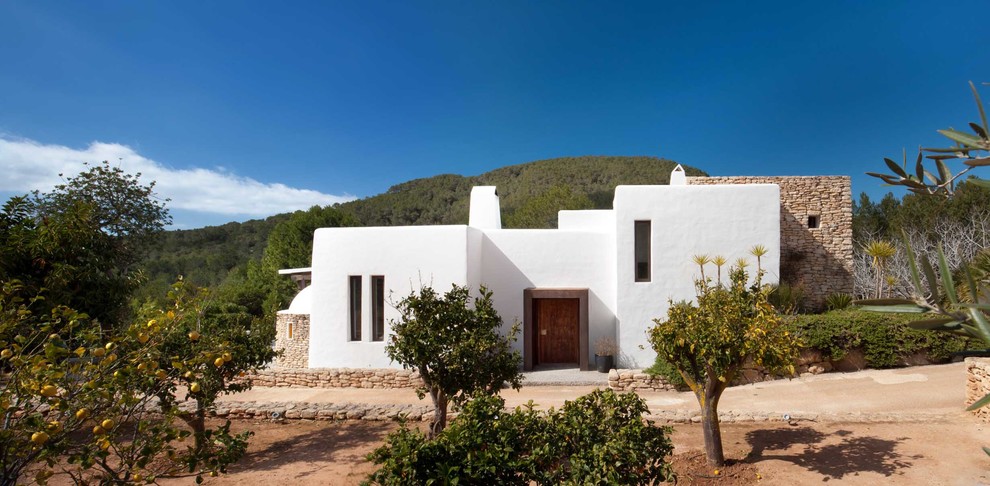 Стильный дизайн: белый, маленький дом в средиземноморском стиле с разными уровнями, облицовкой из самана и плоской крышей для на участке и в саду - последний тренд