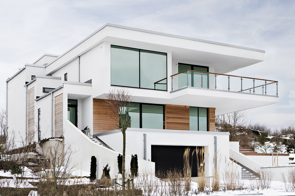 Idées déco pour une façade de maison blanche scandinave en béton à deux étages et plus et de taille moyenne avec un toit plat.