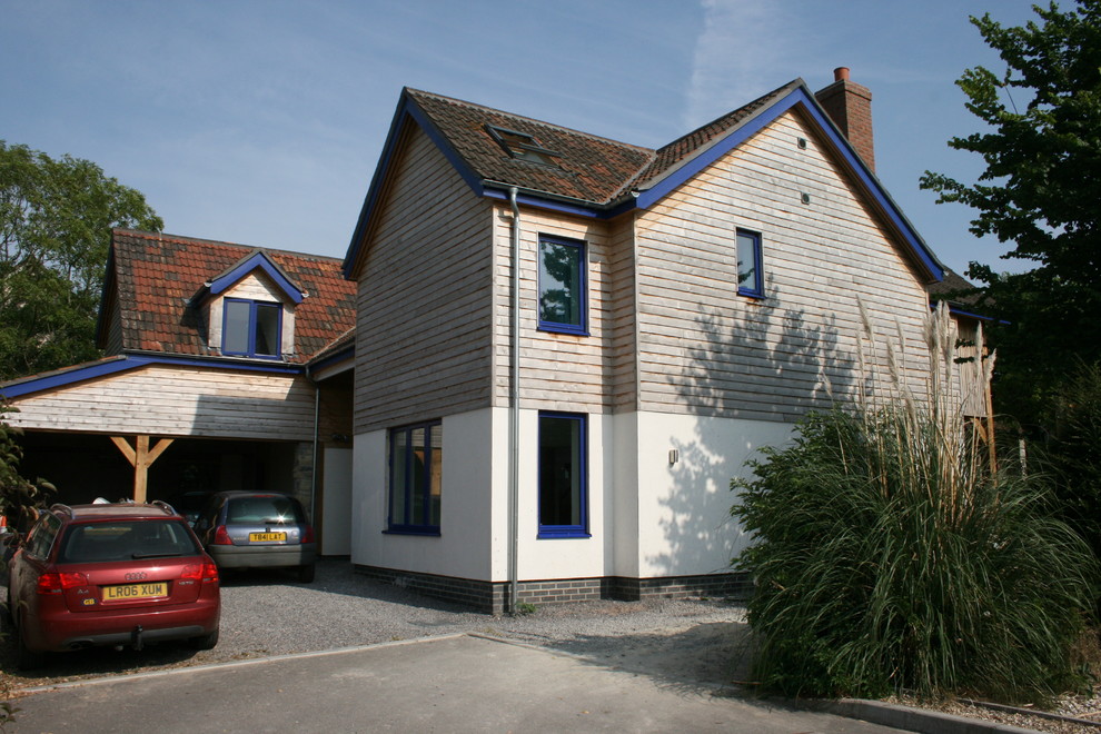 Diseño de fachada blanca de estilo de casa de campo grande de dos plantas con revestimiento de madera y tejado a dos aguas