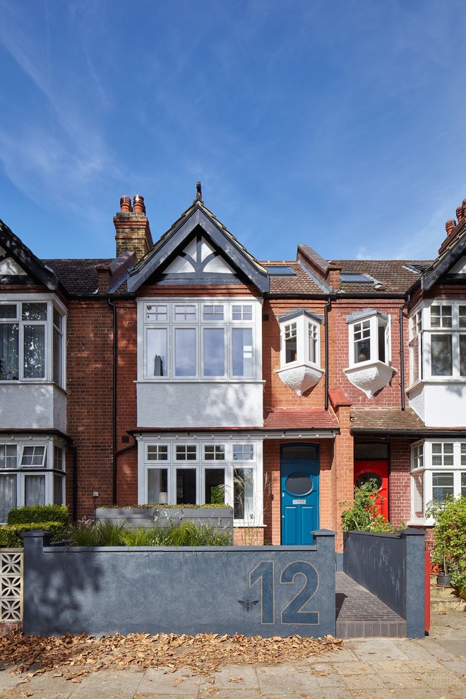 Mid-sized victorian red three-story brick gable roof idea in London
