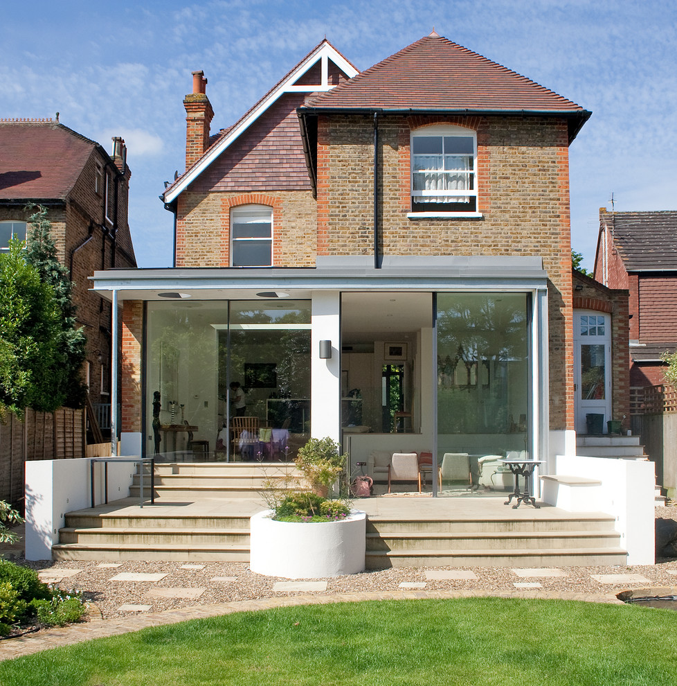 Example of a trendy brick gable roof design in London