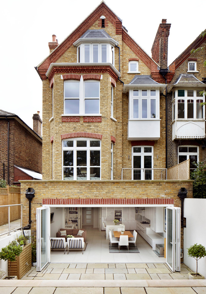 Photo of a traditional brick and rear extension in London with three floors and a pitched roof.