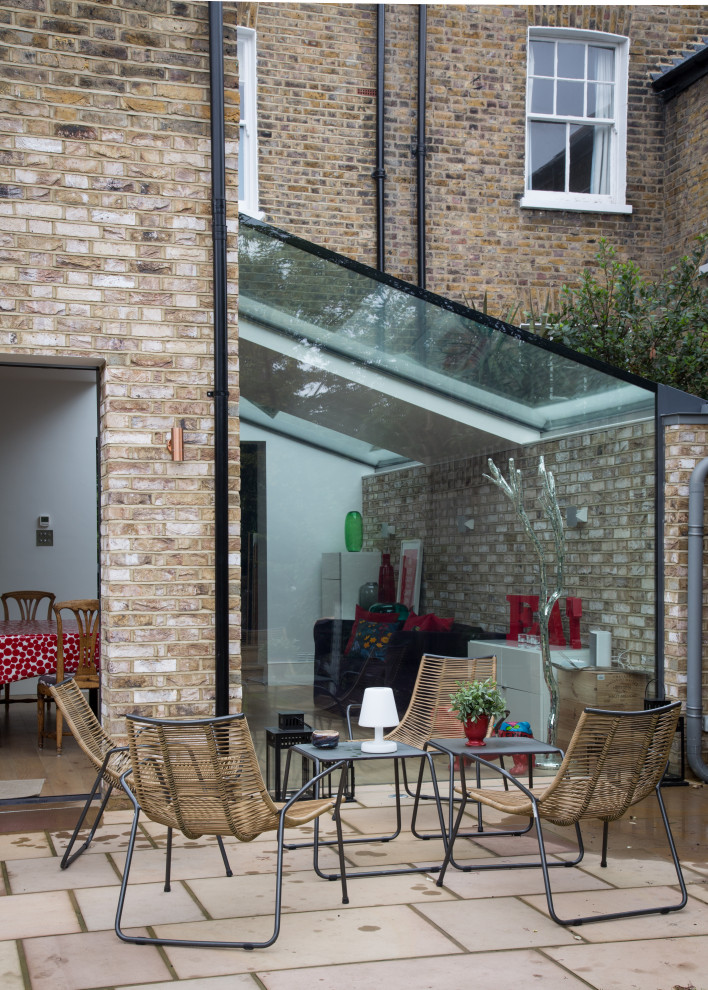 Inspiration for a medium sized contemporary two floor glass terraced house in London with a pitched roof and a tiled roof.