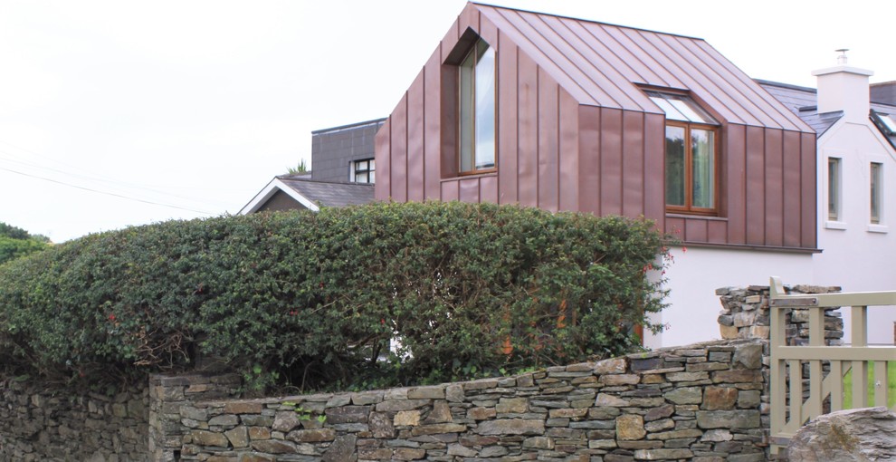 Foto de fachada marrón actual de dos plantas con revestimiento de metal, tejado a dos aguas y tejado de metal