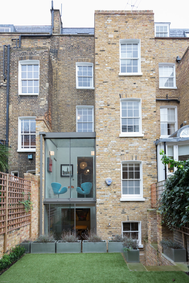 Foto della facciata di una casa contemporanea a tre piani con rivestimento in mattoni
