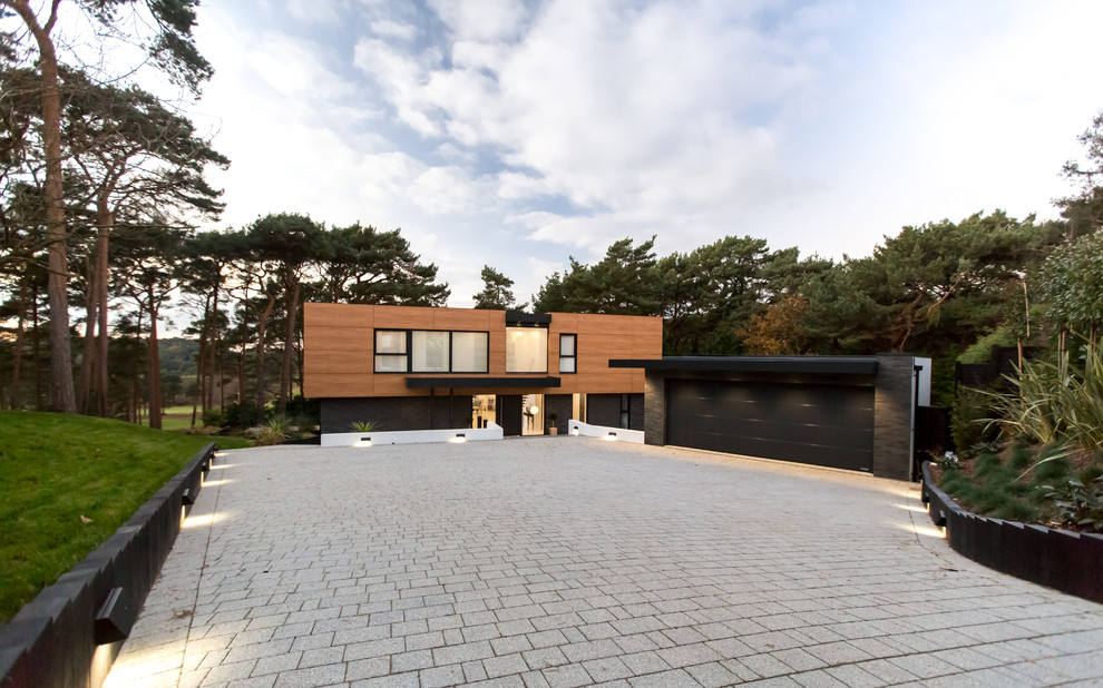 Imagen de fachada de casa multicolor actual con revestimiento de madera y tejado plano