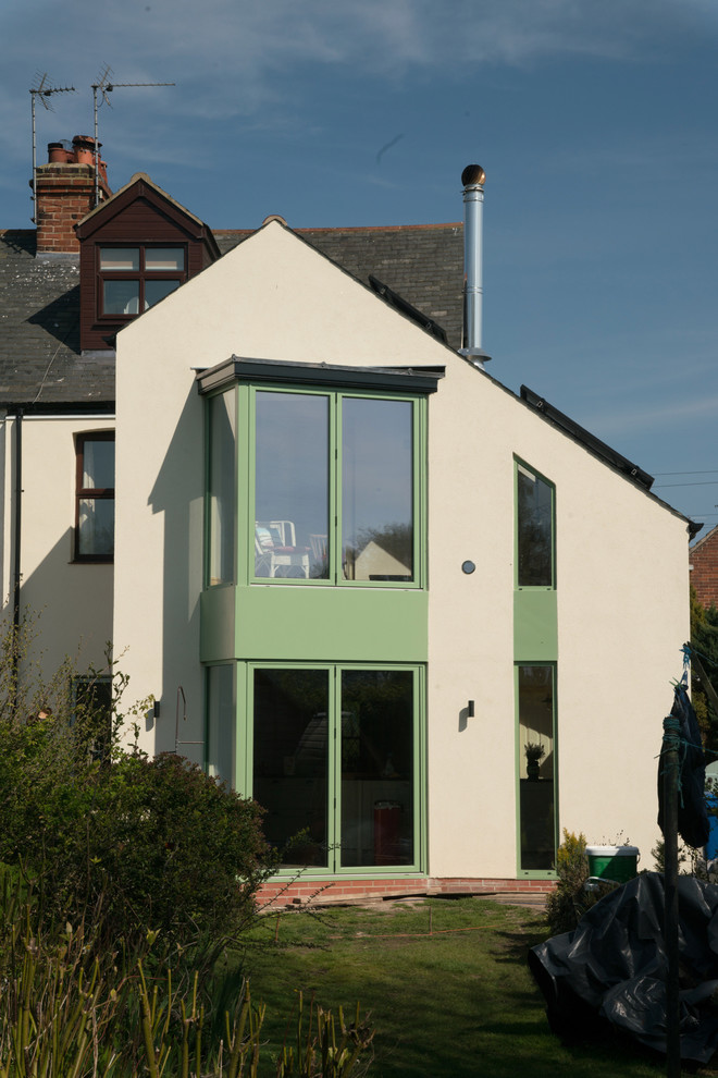 На фото: двухэтажный, бежевый дуплекс среднего размера в современном стиле с облицовкой из цементной штукатурки, двускатной крышей и черепичной крышей