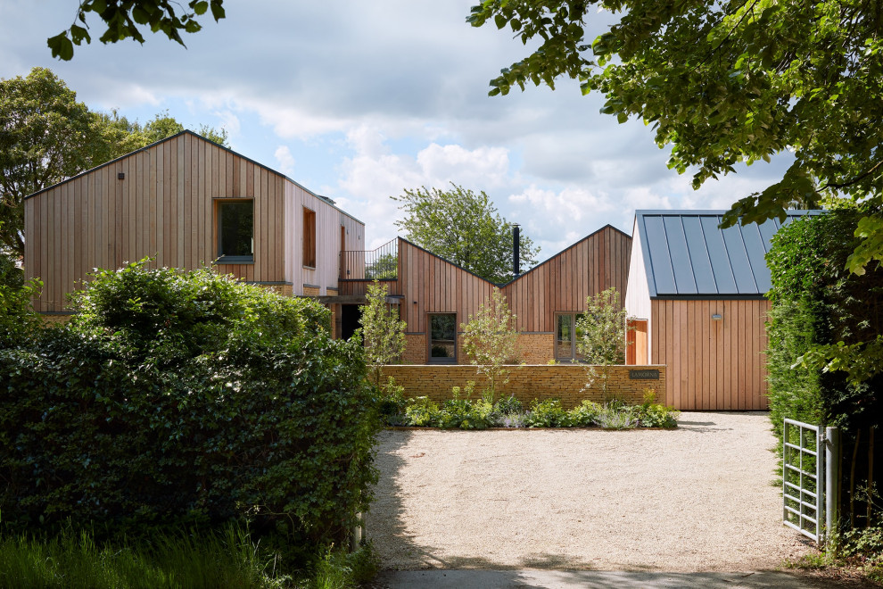 Inspiration for a large and beige scandinavian two floor detached house in Oxfordshire with wood cladding, a pitched roof and a metal roof.