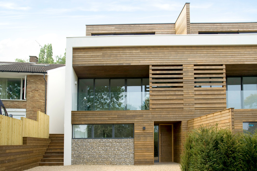 Réalisation d'une façade de maison design en bois à deux étages et plus avec un toit plat.