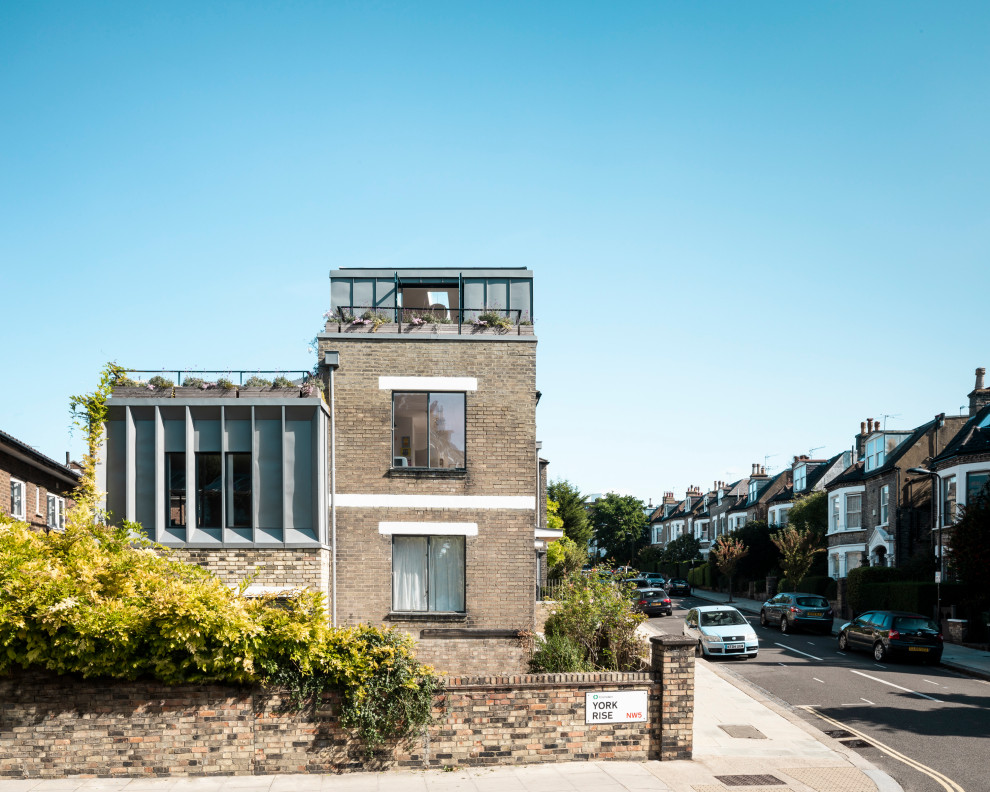 Mid-sized trendy beige three-story metal apartment exterior photo in London with a hip roof and a metal roof