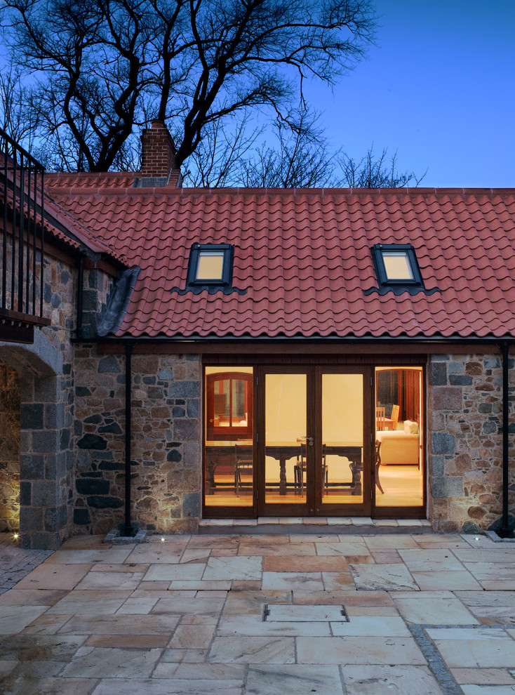 Источник вдохновения для домашнего уюта: одноэтажный дом в стиле кантри с облицовкой из камня и черепичной крышей